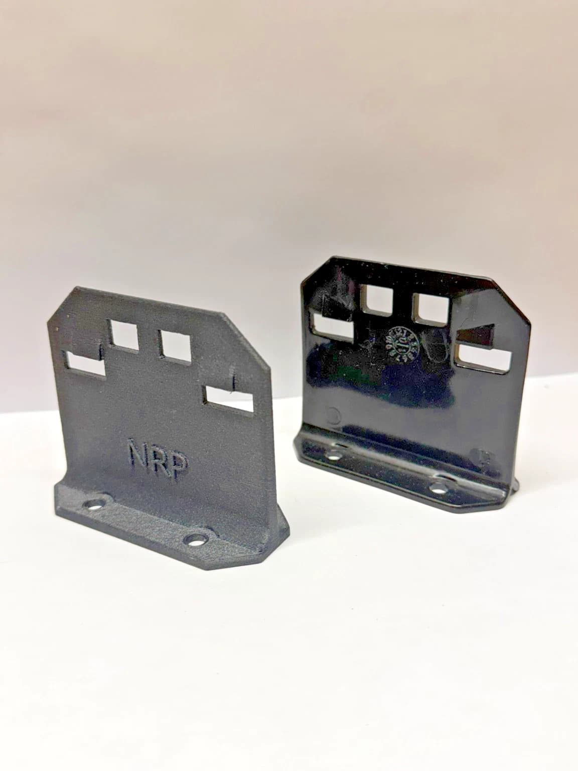 NRP-SP-001 strike plate beside an original strike plate